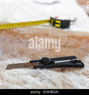 Maßband und Messer auf Mineralwolle, Nahaufnahme Stockfoto