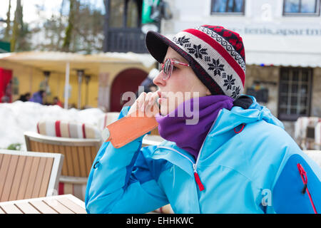 Frau im Skigebiet mit Smartphone. Stockfoto