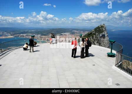 Touristen und Berberaffen auf der Aussichtsplattform mit The Rock und die spanische Küste nach hinten, Gibraltar, Großbritannien Stockfoto