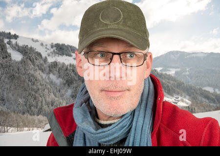 Senior mit Mütze und Brille auf Berg Stockfoto