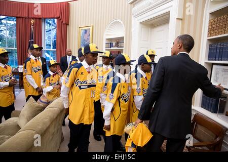 US-Präsident Barack Obama weist darauf hin ein Programm aus der historischen Bürgerrechte Marsch auf Washington für Arbeitsplätze und Freiheit, junge Spieler aus der Jackie Robinson West All Stars während der Team-Besuch zum Oval Office des weißen Hauses 6. November 2014 in Washington, DC. Stockfoto