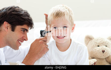 Attraktive Arzt überprüfen Ohren des Patienten Stockfoto