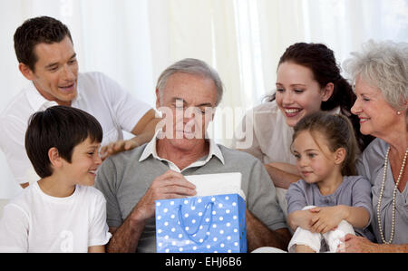 Familie um zu Großvater ein Geschenk geben Stockfoto