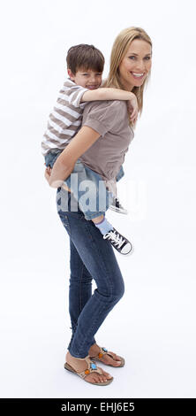 Mutter und Sohn Huckepack-Fahrt Stockfoto