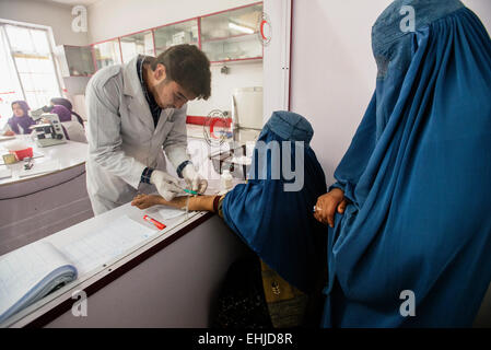 Laborpersonal Rohudin zieht Blut Frau mit Burka für Bluttest im Labor des zentralen Krankenhaus von afghanischen Rothalbmond-Gesellschaft, Kabul, Afghanistan Stockfoto