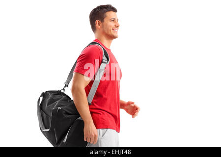 Männliche Athleten gehen mit einer Sporttasche isoliert auf weißem Hintergrund Stockfoto