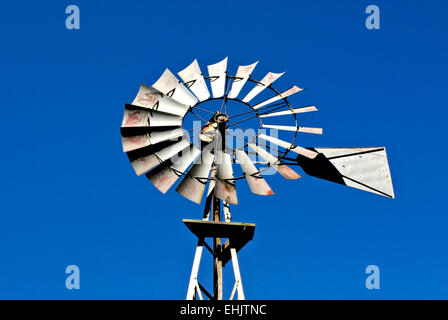 Antike Western rostiges Metall Mühle gegen den klaren blauen Himmel. Stockfoto
