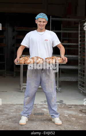 Baker, die holding ein Tablett mit frisch gebackenem Brot Stockfoto