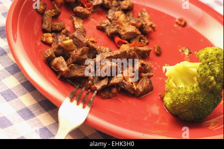 gebratenes Rindfleisch und Brokkoli auf einer roten Platte serviert Stockfoto