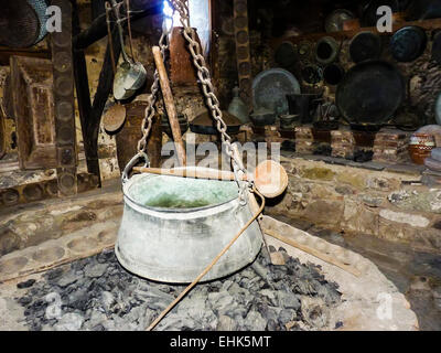 Alte Eisen Kessel Topf und Löffel in traditionelle Küche Stockfoto