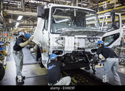 Kawasaki, Japan. 10. März 2015. Eine Mitarbeiter Arbeitskraft des Automobilherstellers Mitsubishi Fuso arbeitet auf einem großen Lastwagen im Mitsubishi Montagewerk in Kawasaki, Japan, 10. März 2015. Foto: Michael Kappeler/Dpa/Alamy Live News Stockfoto