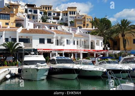 Boote im Innenhafen mit Wohnungen und Restaurants nach hinten, Puerto Cabopino, Costa Del Sol, Provinz Malaga, Spanien. Stockfoto