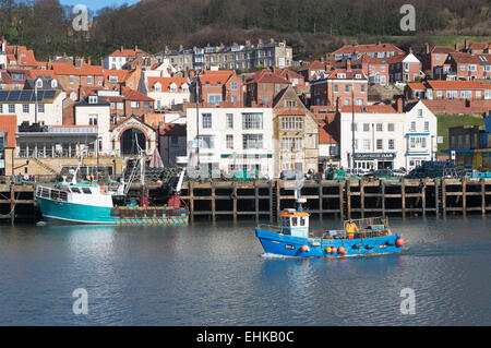 Ein Fischerboot betritt Scarborough Hafen mit der Altstadt im Hintergrund, North Yorkshire, UK Stockfoto