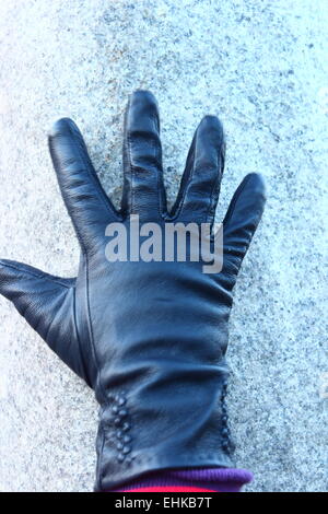 zeigt einen Teil einer behandschuhten Hand schwarz Stockfoto