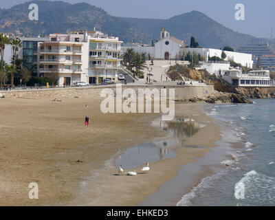 San Sebastian Strand im Badeort Sitges mit Blick auf Kirche, Hügeln und Schwäne am Strand, Katalonien, Spanien Stockfoto