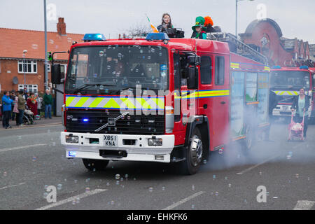 Manchester, UK 15. März 2015.  Manchester & Feuerwehr am Wochenende der St. Patricks Irish Festival.  Tausende Menschen säumten die Straßen mit ansehen, wie die St. Patricks Day Parade bildete seine Weise durch Manchester.  Die farbenfrohe Prozession auf den Weg vom Irish World Heritage Centre in Cheetham Hill vor, der seinen Weg zu Albert Square.  Fahnenträger, die Vertretung der 32 Grafschaften in die Smaragdinsel führte die Parade in der Innenstadt, gefolgt von Schwimmern aus irischen Verbände der Stadt. Stockfoto