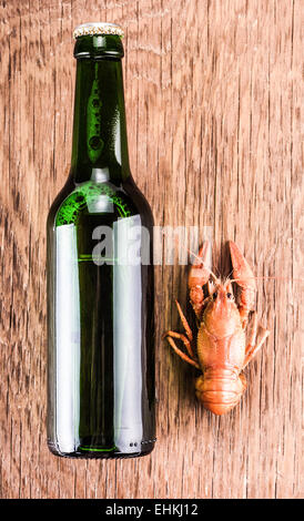 Bier in einer Glasflasche und Krebs auf dem hölzernen Hintergrund Stockfoto
