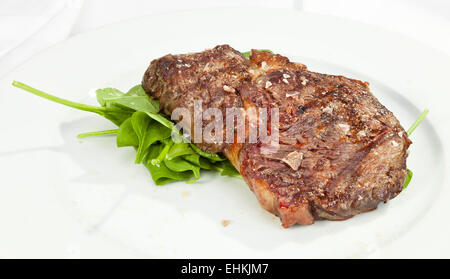 Gegrilltes Rumpsteak mit Spinat und grobem Salz Stockfoto