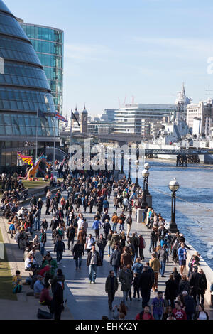 Massen zu Fuß entlang der Themse auf ein sonniges Wochenende. Ansicht des Rathauses von der Tower Bridge Stockfoto