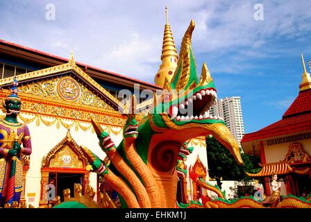 Georgetown, Malaysia: Giant Dragon mit Naga Köpfe und Guardian Dämon am Eingang um 1900 Thai Wat Chaiyamangalaram Stockfoto