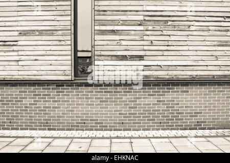 Ziegel und Holz Mauer auf einem modernen Eco Gebäude in Sepia-Tönen Stockfoto