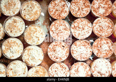 Mini-cremige Desserts in kleinen Plastikwannen Stockfoto