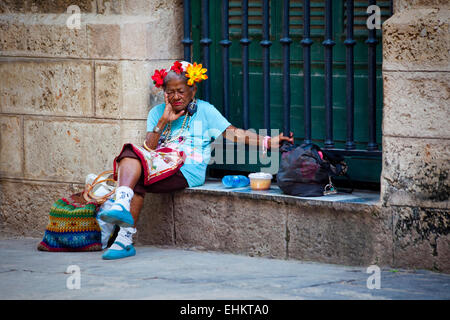 Eine alte Frau sitzt auf der Straße in Havanna, Kuba Stockfoto