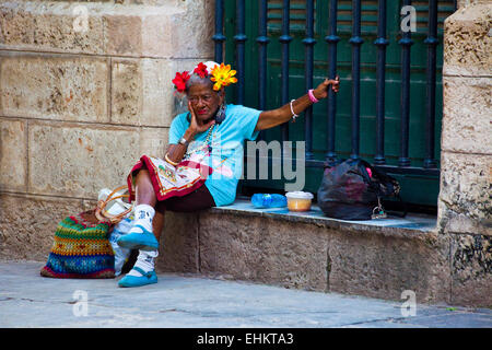 Eine alte Frau sitzt auf der Straße in Havanna, Kuba Stockfoto