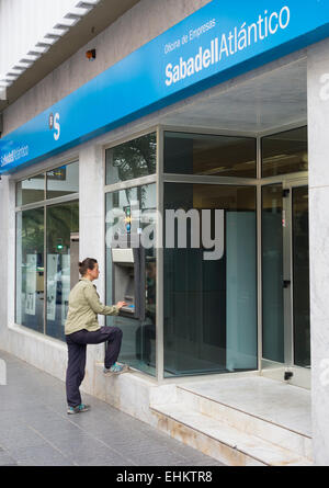 Spanierin mit ATM Maschine Outsdie spanische Bank, Sabadell Stockfoto