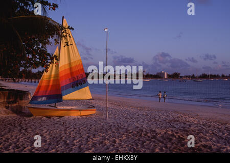 Segelndes Beiboot bei Sonnenuntergang am Strand von Carlisle Bay, Bridgetown, Barbados, West Indies Stockfoto