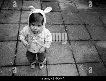 Kleines Mädchen schauen traurig in Kapuzenshirt mit Hasenohren Stockfoto