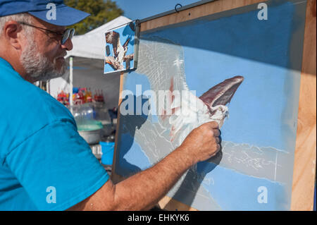 Ein Künstler mit Kreide auf einer Zeichnung auf einer Veranstaltung in Tavares, Florida setzt einen Stand für die Darstellung seiner Arbeit. Stockfoto