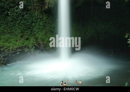 Touristen, die in einem Wasserfall schwimmen in der Nähe von La Fortuna, Costa Rica. Stockfoto