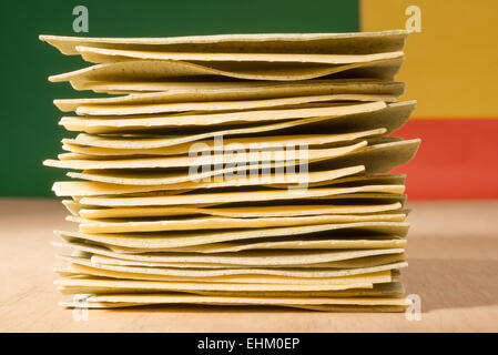 Rohe Stück Lasagne auf einander gestapelt werden, vor den drei Farben der italienischen Flagge, Rot, Gelb und Grün. Stockfoto