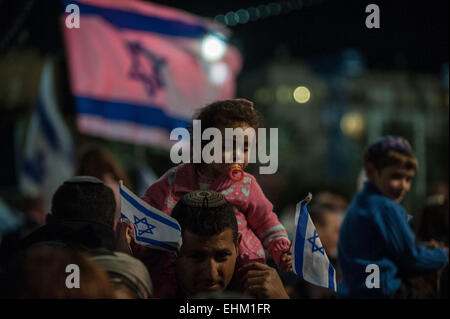 Tel Aviv, Israel. 15. März 2015. Ein Mann besucht eine rechtsextreme Großkundgebung mit seiner Tochter auf Rabin-Platz in Tel Aviv, Israel, am 15. März 2015. Tausende von rechtsradikalen Israelis versammelten sich an einem Platz in zentralen Tel Aviv Sonntag um Unterstützung für Premierminister Benjamin Netanyahu dessen Angebot Wiederwahl Dienstages Wahlen zeigen hat eine starke Herausforderung aus dem Lager der Opposition getroffen. Bei der Rallye fordert Netanyahu Israelis für seine rechtsgerichtete Likud-Partei zu stimmen, der hinter der Mitte-links-zionistischen-Union in Meinungsumfragen zurückgeblieben ist. © Li Rui/Xinhua/Alamy Live-Nachrichten Stockfoto