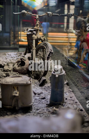 Bandung, Indonesien. 15. März 2015. Kinder zu beobachten, dass ein beschädigtes Motorrad getroffen pyroklastische Ströme, Geologie-Museum, Bandung, Indonesien. Das Artefakt stammt von 2010 Mount Merapi Ausbruch Website in Yogyakarta Provinz. Stockfoto