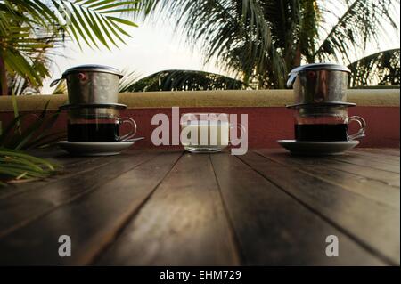 Vietnam tropft Kaffee mit Milch unter Palmen Stockfoto