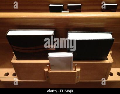 Nahaufnahme von Bibeln in Halterung hinter Kirche pew Stockfoto