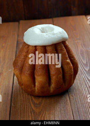 Rum Baba auf hölzernen Hintergrund. Kuchen in gesättigten Schnaps, in der Regel rum und manchmal gefüllt mit gepeitschter Creme oder Gebäck Cr Stockfoto