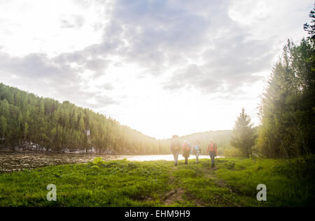 Kaukasische Touristen zu Fuß in der Nähe von Fluss in abgelegenen Landschaft Stockfoto