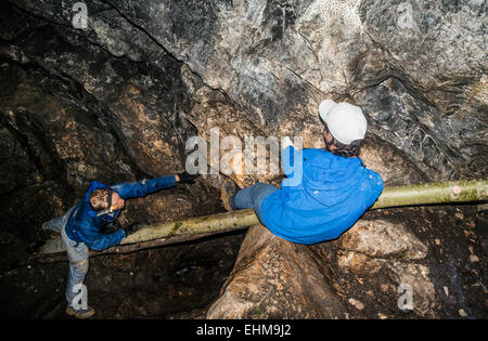 Kaukasische Kletterer erkunden Felsformation Höhle Stockfoto