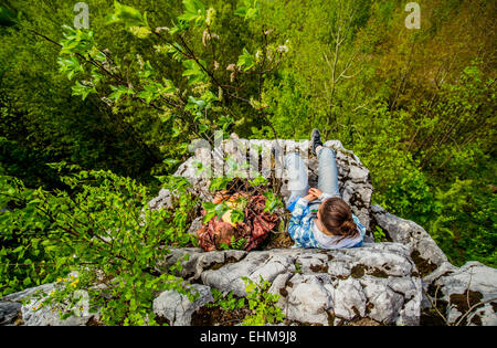 Erhöhte Ansicht des Kaukasischen Mädchen sitzen auf Klippe Stockfoto
