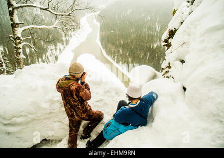 Kaukasische Wanderer genießen Aussicht vom verschneiten Hügel Stockfoto