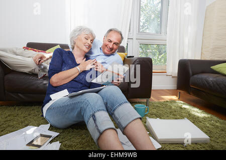 Älteres Ehepaar Blick auf Fotos im Wohnzimmer Stockfoto