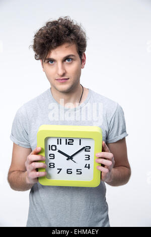 Gut aussehend männlichen Studenten mit großen Uhr auf grauem Hintergrund Stockfoto