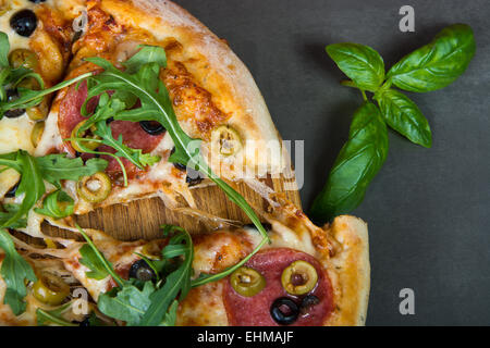 Frische würzige italienische Pizza mit Salami Wurst und Rucola Stockfoto