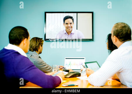 Geschäftsleute, die mit video-Konferenz im Büro treffen Stockfoto