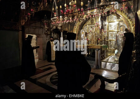 Griechisch-orthodoxen Priester im Rahmen einer Masse Prozession vor dem Altar der Kreuzigung auf der linken Seite der Kalvarienberg oder Golgatha traditionell als Ort der Kreuzigung Jesu betrachtet. Der Hauptaltar gehört der griechisch-orthodoxen, der den Fels von Golgatha 12. Station des Kreuzes enthält im Inneren der Kirche des Heiligen Grabes christlichen Viertel Altstadt Ost Jerusalem Israel Stockfoto