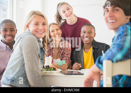 Jugendliche, die lächelnd am Tisch Stockfoto