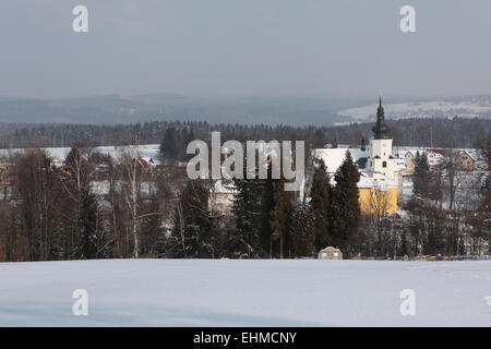 Winterlandschaft mit Dorf Jindrichovice im Hintergrund in Westböhmen, Tschechien. Stockfoto